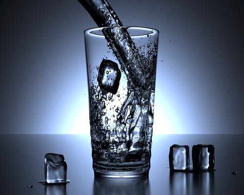 Person pouring drinking water in a glass at office desk